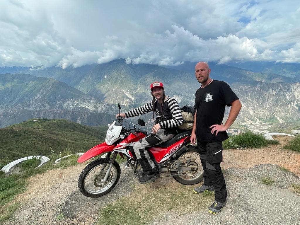 two dudes at the top of a canyon by moto